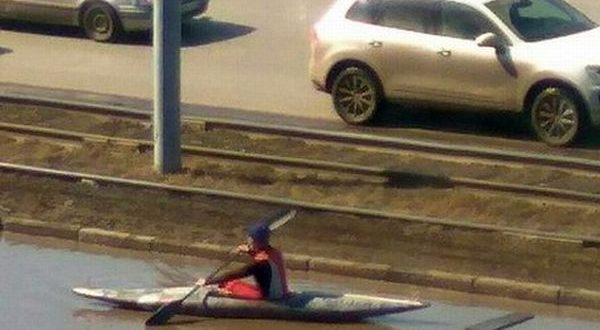 Житель Омска устроил заплыв на байдарке в луже в центре города